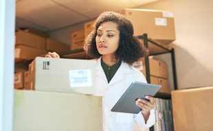 Shot of a young woman using a digital tablet while doing inventory in the storeroom of a pharmacy