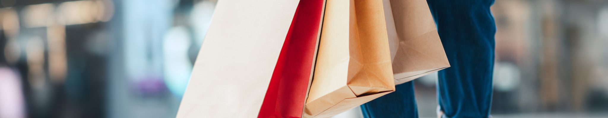 Closeup - Woman holding sale shopping bags. Consumerism, shopping, lifestyle concept